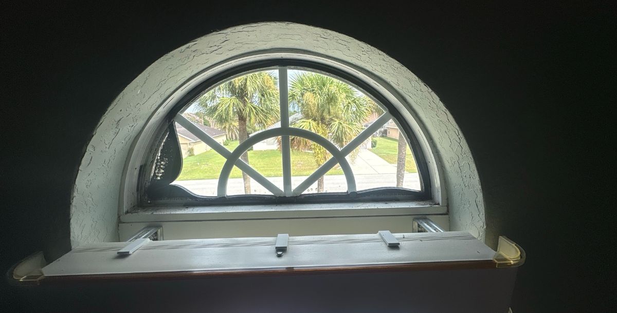 Insulated glass unit being removed from an arched picture window