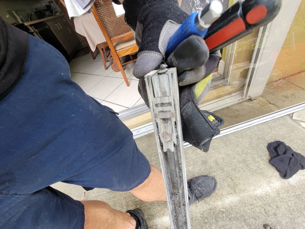 Technician holding a sliding door roller assembly