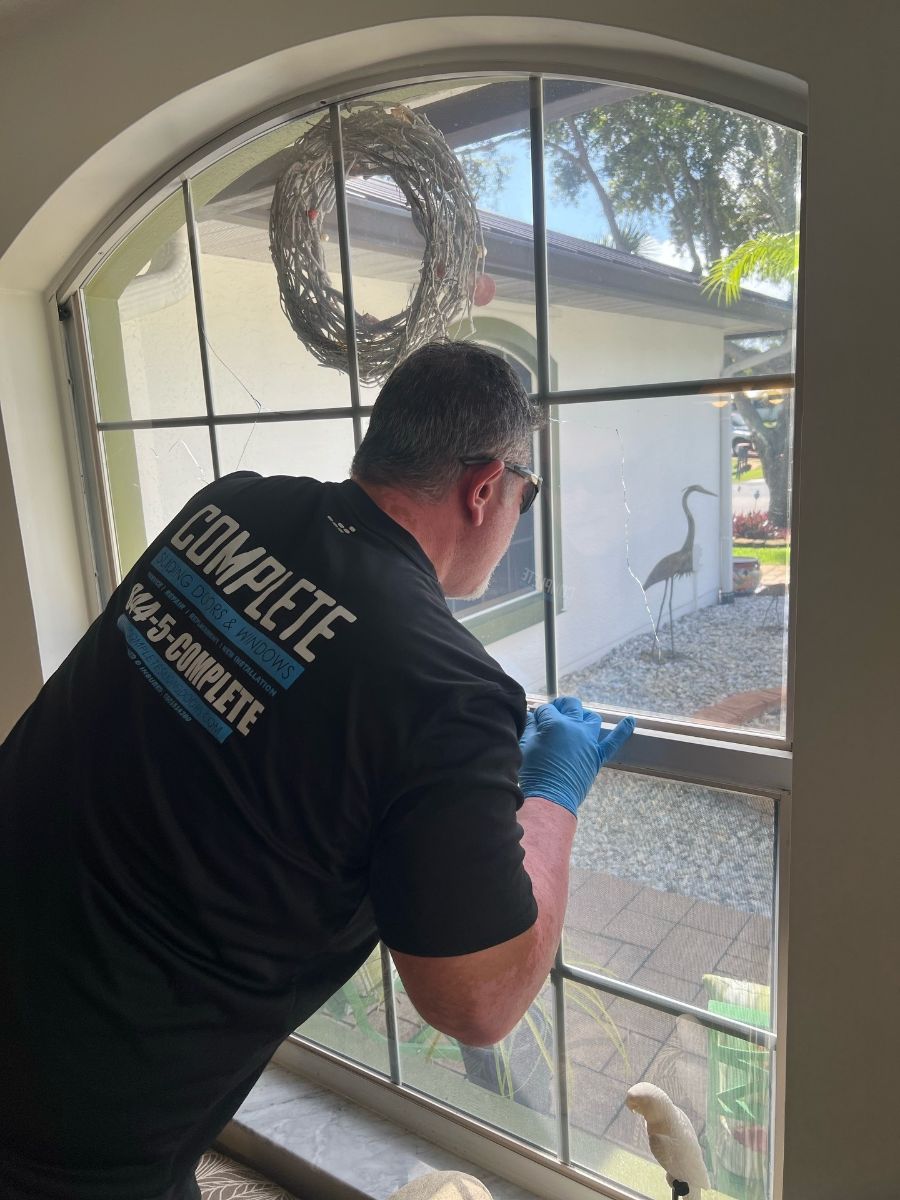 Technician removing a cracked window pane for replacement